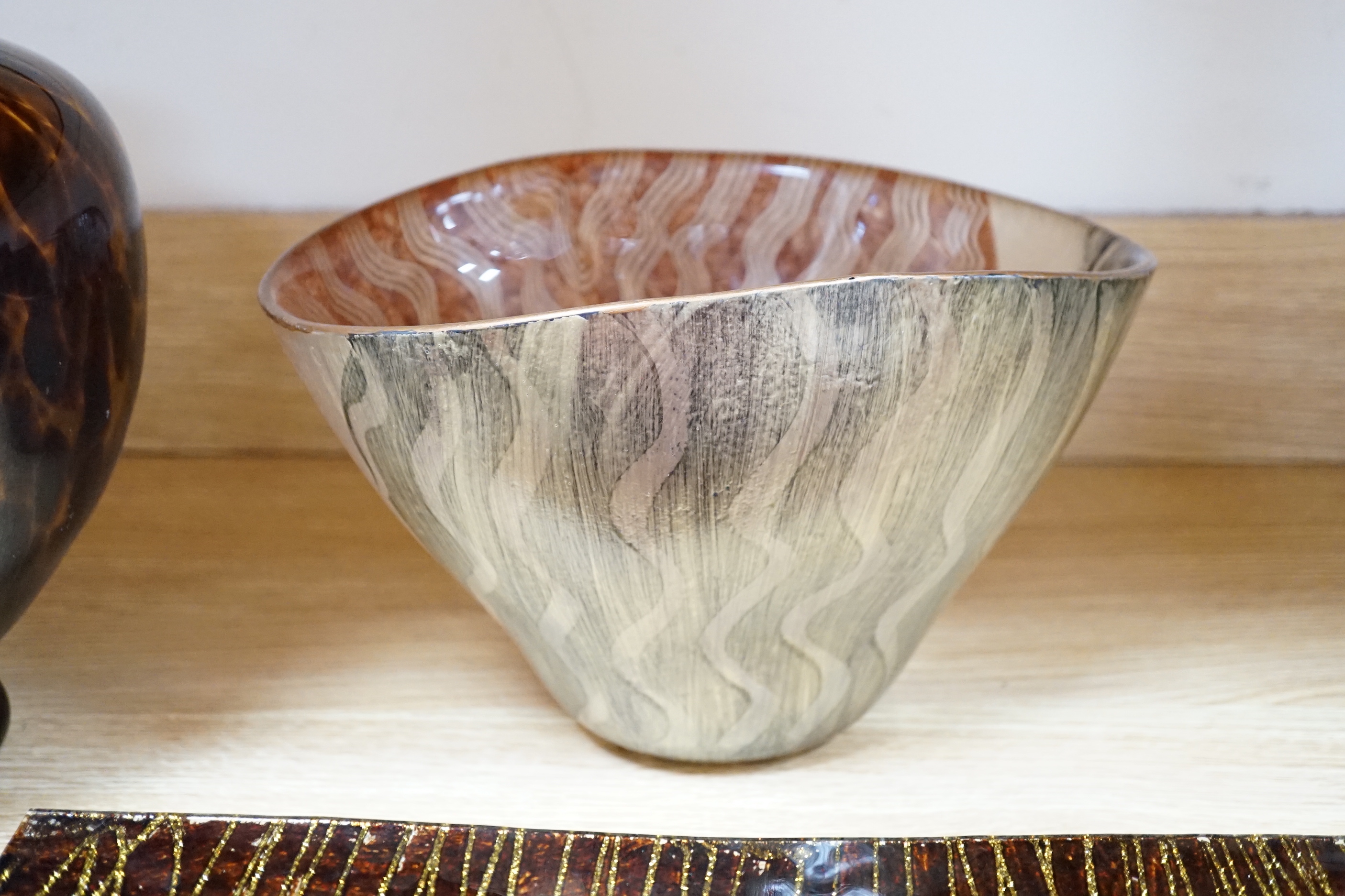 A faux tortoiseshell glass vase, an art glass vase and two Art glass dishes, the largest 41cm wide